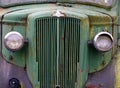 Close up of the front of an old abandoned rusting green truck covered in moss Royalty Free Stock Photo