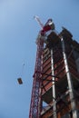 crain lifting contruction material up a framed building skyscraper