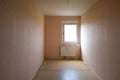 Cramped unrenovated room intended as enough space in a typical rental apartment in social housing with cheap flooring, exposed