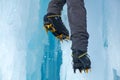 Crampons close-up on his feet ice climber on a frozen waterfall. Shards of ice