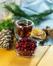 Cranberries in a glass plate. Frozen lingonberries in a glass plate on a wooden table.