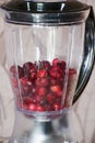 Cranberry in blender. Mixed berries in a blender. Jjuicy cranberries. Pureed cranberries with sugar.