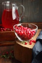 Cranberry cold drink in glass pitcher with red berries on wooden rustic background, closeup, winter christmas holiday drinks Royalty Free Stock Photo