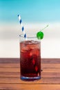 Cranberry icy cocktail on the glass table at the beach with ocean Royalty Free Stock Photo