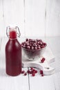 Cranberry juice in a bottle and a cranberries in a glass bowl