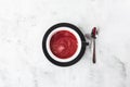 Cranberry, red or raspberry tea in dark cup isolated on bright marble background. Overhead view, copy space. Advertising for cafe Royalty Free Stock Photo