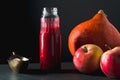 Cranberry sauce in a bottle, pumpkin and apples on a table side view