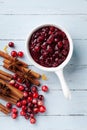 Cranberry sauce in ceramic saucepan with ingredients for cooking on blue wooden table top view Royalty Free Stock Photo
