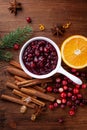 Cranberry sauce in ceramic saucepan with ingredients for cooking decorated with fir tree for Christmas or Thanksgiving day Royalty Free Stock Photo