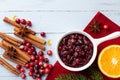 Cranberry sauce in ceramic saucepan with ingredients for cooking decorated with fir tree for Christmas or Thanksgiving day Royalty Free Stock Photo