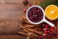 Cranberry sauce in ceramic saucepan with ingredients for cooking decorated with fir tree for Christmas or Thanksgiving day on wood Royalty Free Stock Photo