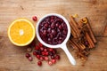 Cranberry sauce in ceramic saucepan with ingredients for cooking on kitchen wooden table top view Royalty Free Stock Photo