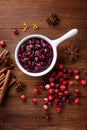 Cranberry sauce in ceramic saucepan with ingredients for cooking on kitchen wooden table from above Royalty Free Stock Photo