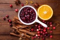 Cranberry sauce in ceramic saucepan with ingredients for cooking on kitchen wooden table from above Royalty Free Stock Photo