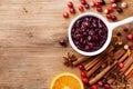 Cranberry sauce in ceramic saucepan with ingredients for cooking on kitchen wooden table top view Royalty Free Stock Photo