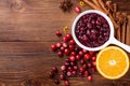 Cranberry sauce in ceramic saucepan with ingredients for cooking on kitchen wooden table top view Royalty Free Stock Photo