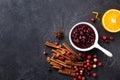 Cranberry sauce in ceramic saucepan with ingredients for cooking on stone black table top view Royalty Free Stock Photo