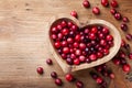 Cranberry in wooden bowl on rustic table top view Royalty Free Stock Photo