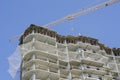 Crane above the high-rise building under construction close-up Royalty Free Stock Photo