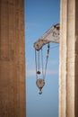 Crane appearing between two marble Parthenon columns Royalty Free Stock Photo