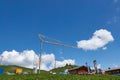 Crane atop a hill in the mountains of Graubunden, Switzerland near a quaint wooden house