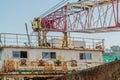 Crane boom attached to upper deck of old barge