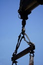 Crane boom with isolated hook, blue sky background,Elements of crane: hook, loop, chain, connecting parts Royalty Free Stock Photo