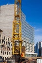 Crane and building construction site against blue sky, close-up Royalty Free Stock Photo