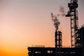 Crane and building construction site with pipe with smoke on background of sunset sky. Industrial landscape with silhouettes of c Royalty Free Stock Photo