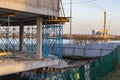 Crane and building under construction against blue sky on lake bank. Urban landscape Royalty Free Stock Photo