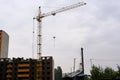 A crane builds a house at a height, lifts the load to the upper floor. The construction site of a residential building Royalty Free Stock Photo
