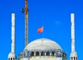 Crane builds up new turkish mosque in istanbul. Dome, minarets and crane against the blue sky Royalty Free Stock Photo