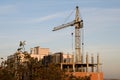 Crane at construction site in front of blue sky Royalty Free Stock Photo