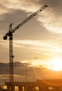 Crane at construction site and sunset sky Royalty Free Stock Photo