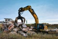 crane or excavator equipped with a grapple handling large rocks Royalty Free Stock Photo