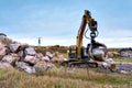 crane or excavator equipped with a grapple handling large rocks Royalty Free Stock Photo