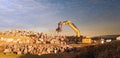 crane or excavator equipped with a grapple handling large rocks Royalty Free Stock Photo