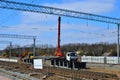 Crane and excavator work on the construction site on the railway, laying rail Royalty Free Stock Photo