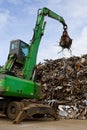 A crane grabber loading a metal