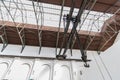 old iron chain hoist with hook moving on rails in hangar. bottom view of the industrial shop with a mechanical Jack. crane hook in