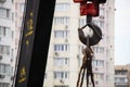 Crane hook. Tower Crane Hoist Rope against the blue sky and new building. Hawser of winch. Crane lifting cables. Construction site