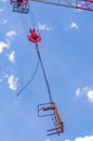 Crane, host and empty carrage, swining in tropical blue sky Royalty Free Stock Photo