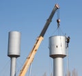 A crane installs a water tower.