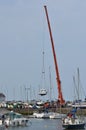 Crane lifting boat at harbourside.