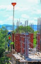 Crane lifting concrete mixer container and worker in construction building commercial in site workplace