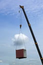 Crane lifting cutoff container moving in to the sky.