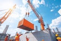 A crane is lifting a large orange container Royalty Free Stock Photo