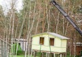 Crane lifting up the tiny house outdoors in spring. Royalty Free Stock Photo