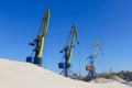 Crane loading industrial cargo ship with gravel Royalty Free Stock Photo