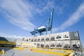 Crane lowering container to stack of containers. Royalty Free Stock Photo
